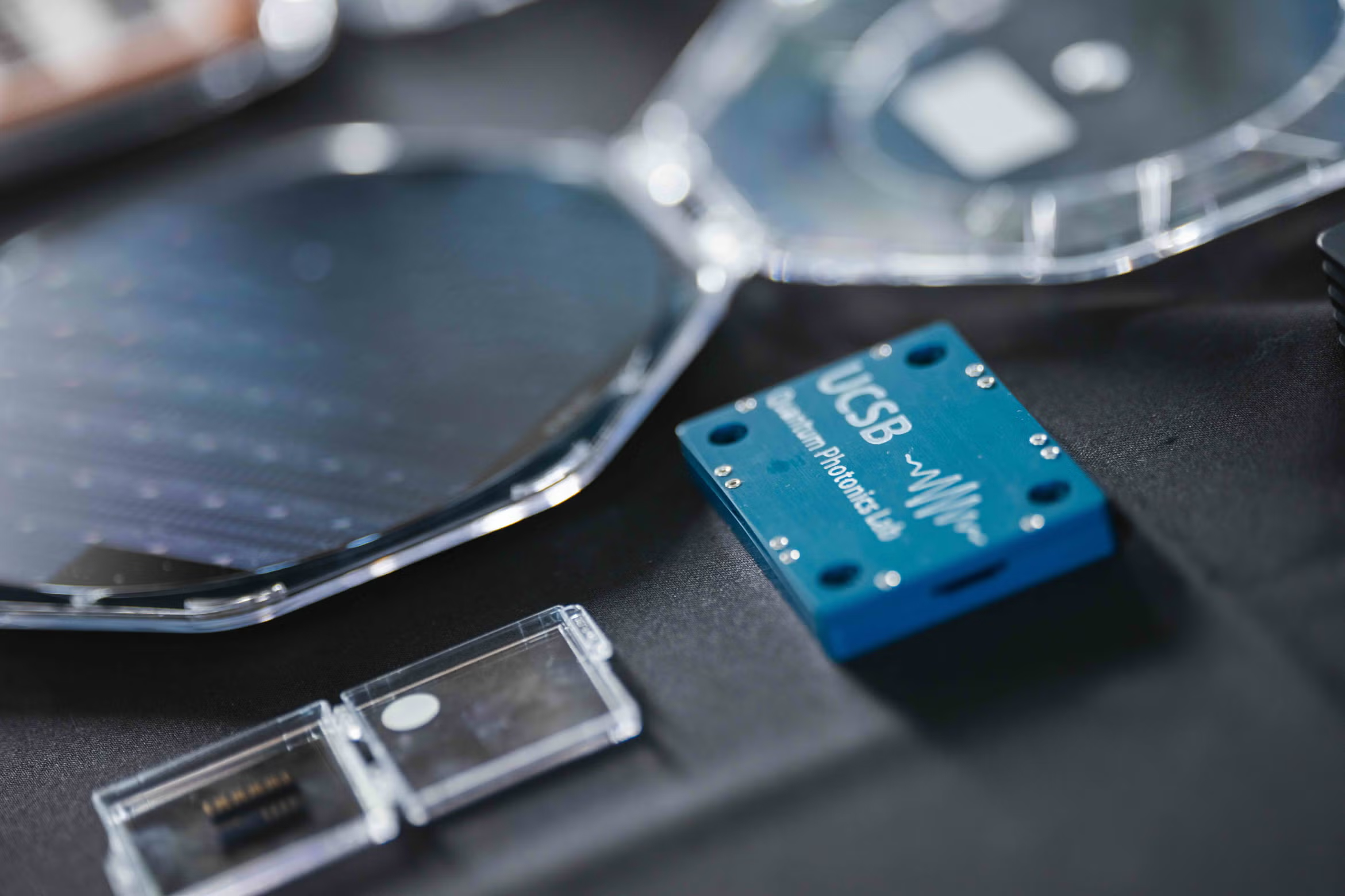 Close-up of a blue quantum photonics chip labeled "UCSB Quantum Photonics Lab.